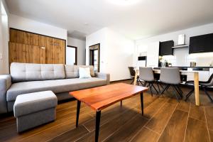 - un salon avec un canapé et une table dans l'établissement Silver Home Apartman "A", à Balatonalmádi