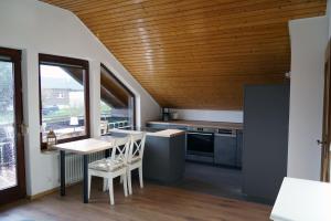 a kitchen with a wooden ceiling and a table and chairs at FeWo Horb Am Neckar in Horb am Neckar