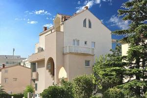 un gran edificio blanco con balcón. en Apartments Villa Desire en Makarska