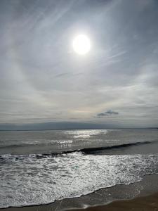 a beach with the sun shining on the water at Grannies Heilan Hame in Dornoch