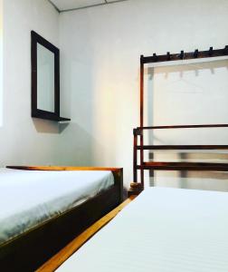 2 Betten in einem Zimmer mit Spiegel und Fenster in der Unterkunft Thissawewa Guest in Anuradhapura