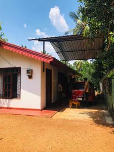 Ein Mann und ein Hund stehen vor einem Haus. in der Unterkunft Thissawewa Guest in Anuradhapura