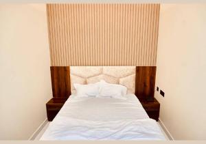 1 dormitorio con 1 cama grande con sábanas y almohadas blancas en Hotel Rameshwaram, Mathura, en Mathura