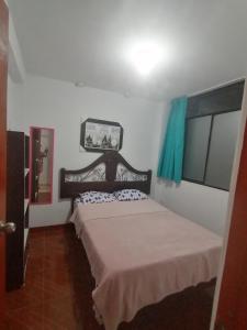 a bedroom with a bed in a white room at Departamento-Bolognesi B1 in Chiclayo