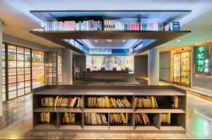 eine Bibliothek mit mehreren Regalen voller Bücher in der Unterkunft Hansen Hotel in Hangzhou