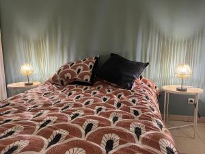 een bed in een slaapkamer met 2 lampen op tafels bij Appartement lumineux terrasse piscine in Cugnaux