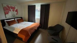 1 dormitorio con 1 cama, 1 silla y 1 ventana en Mo Gjestegård en Mo i Rana