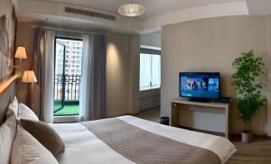 a bedroom with a bed with a television and a window at Hansen Hotel in Hangzhou
