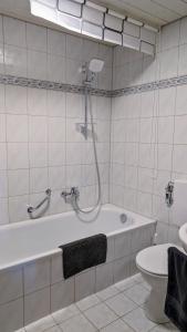 ein Badezimmer mit einer Dusche, einer Badewanne und einem WC in der Unterkunft Bei den Hartmanns in Rieden