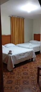 a room with two beds and a curtain at HOSPEDAJE BUENA VISTA in Ayacucho