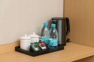 a shelf with two bottles of water and a coffee maker at Hualv Hotel - Guangzhou Beijing Road Pedestrian Street Provincial People's Hospital in Guangzhou