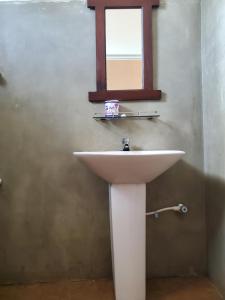 um lavatório branco numa casa de banho com uma janela em Hoxton Bay Surf House weligama em Weligama
