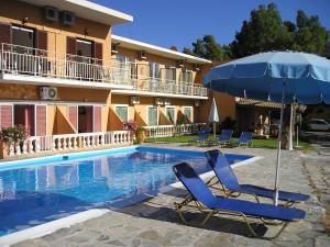 a pair of chairs and an umbrella next to a swimming pool at River Studios & Apartments in Mesongi