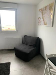 uma cadeira de feijão preto num quarto com uma janela em Studio vue sur mer classé 3 étoiles, Calais em Calais