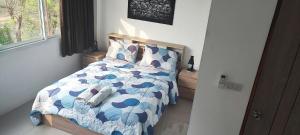 um quarto com uma cama com um edredão azul e branco em Dorothys em Pattaya Sul