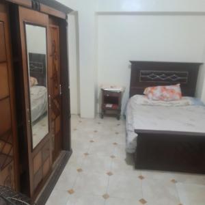 um quarto com uma cama, uma cómoda e um espelho em شقة مفروشة غرفتين بمدخل مستقل em Kafr Abū Dabbūs