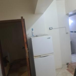 uma cozinha com um frigorífico branco num quarto em شقة مفروشة غرفتين بمدخل مستقل em Kafr Abū Dabbūs