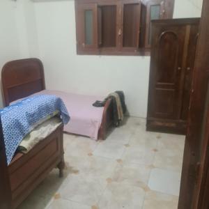 um pequeno quarto com uma cama e um armário em شقة مفروشة غرفتين بمدخل مستقل em Kafr Abū Dabbūs