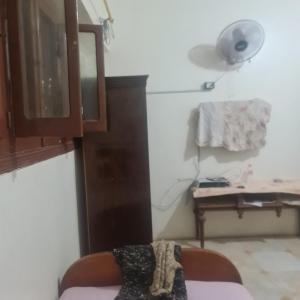 um quarto com uma cadeira, um candeeiro e uma secretária em شقة مفروشة غرفتين بمدخل مستقل em Kafr Abū Dabbūs