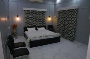 ein Schlafzimmer mit einem Bett und einem Stuhl in der Unterkunft Janki Kunj Varanasi- 3 Room Home in Varanasi