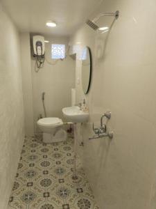 y baño con aseo, lavabo y espejo. en Janki Kunj Varanasi- 3 Room Home, en Varanasi