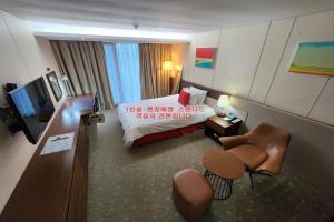 a hotel room with a bed and a couch at Ramada by Wyndham Jeju Hamdeok in Jeju