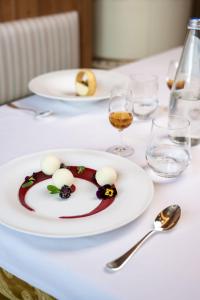 a white plate with a dessert on a table at Tevini Dolomites Charming Hotel in Commezzadura