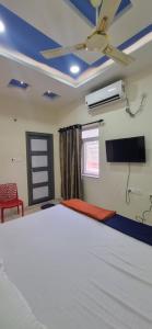 a bedroom with a large bed with a ceiling fan at Veda Residency in Machilīpatnam