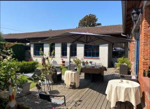 eine Terrasse mit einem Tisch und einem Sonnenschirm in der Unterkunft Le Château de Failloux Piscine interieure Sauna in Épinal