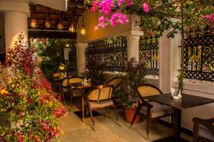 um restaurante com mesas, cadeiras e flores em Shikara Beach Resort em Cavelossim