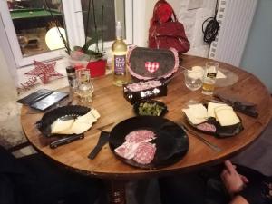 una mesa de madera con carne y queso. en Chambre pour 2 personnes avec un lit, en Chef-Boutonne