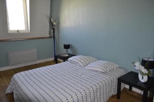 1 dormitorio con 1 cama con edredón blanco y negro en Chambre pour 2 personnes avec un lit, en Chef-Boutonne