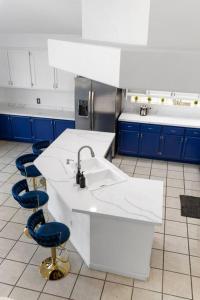 a kitchen with a sink and two blue chairs at Heated Pool - Poker - 5 min - Airport - 10-Strip in Las Vegas