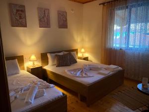 two beds in a room with two lamps and a window at Villa Berat - Castle View & Traditional Breakfast in Berat