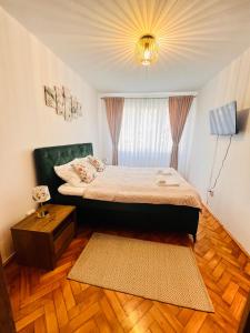 1 dormitorio con cama, ventana y alfombra en Apart Relax Turda, en Turda