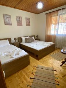 two beds in a room with wooden floors at Villa Berat - Castle View & Traditional Breakfast in Berat +40 photos
