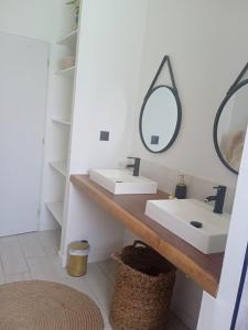 uma casa de banho com 2 lavatórios e um espelho em Villa pampa em Malves