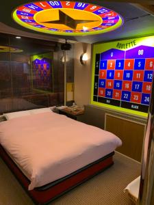 Iwakiriにあるホテル　プレリュードのベッド1台付きの部屋、壁にビデオゲームが備わる客室です。