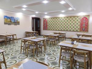 a dining room with tables and a painting on the wall at CARAVAN PLAZA BOUTIQUE in Bukhara