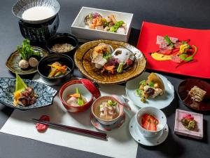 une table recouverte de assiettes et de bols de nourriture dans l'établissement Nagominoyado Hanagokoro - Reopening in Mar 2024, à Hakone