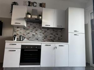 a kitchen with white cabinets and a black oven at ANCORA...IO E TE in Focene +22 photos