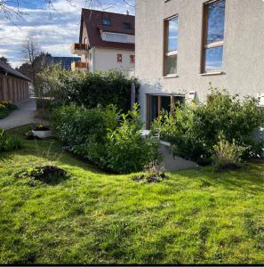 un patio con algunos arbustos y una casa en Fewo Spectrum, en Überlingen
