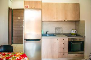 a kitchen with a stainless steel refrigerator and wooden cabinets at Filippou 13 Luxury APRTS in Thessaloniki