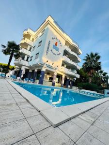 a hotel with a swimming pool in front of it at Trilocale Fronte Mare Pineto in Pineto