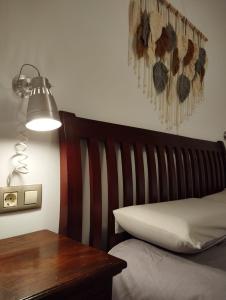 1 dormitorio con 1 cama con cabecero de madera y mesa en Acogedor Apartamento Céntrico en La Puebla de Valverde