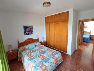 una camera con letto e armadio in legno di Adosado con garaje privado - Junto al mar a Los Nietos