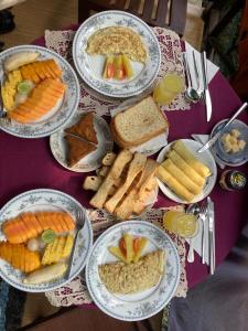 una mesa con platos de comida en una mesa púrpura en Dosemo Cabana, en Induruwa