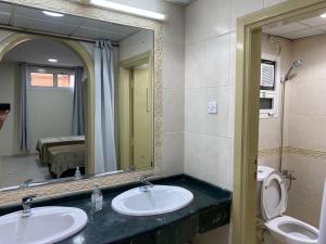 a bathroom with two sinks and a mirror at The Family in Abu Dhabi