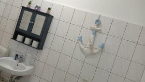 baño de azulejos blancos con lavabo y cepillo de dientes en Stellas Monteurwohnungen, en Crimmitschau