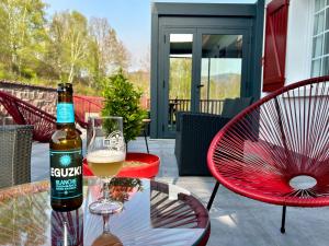 una botella de cerveza sentada en una mesa con un vaso en LOGIS Hôtel St Sylvestre, en Aldudes